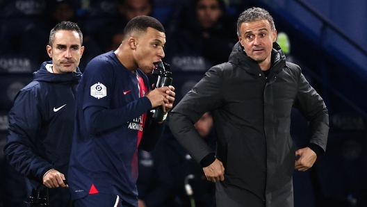 Paris Saint-Germain's French forward #07 Kylian Mbappe celebrates with Paris Saint-Germain's Spanish headcoach Luis Enrique after scoring his team's third goal a during the French L1 football match between Paris Saint-Germain (PSG) and FC Metz at the Parc des Princes stadium in Paris, on December 20, 2023. (Photo by FRANCK FIFE / AFP)