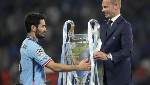 FILE - UEFA president Aleksander Ceferin hands the trophy to Manchester City's team captain Ilkay Gundogan after the the Champions League final soccer match between Manchester City and Inter Milan in Istanbul, Turkey, Sunday, June 11, 2023. The European Union?s top court has ruled UEFA and FIFA acted contrary to EU competition law by blocking plans for the breakaway Super League. The case was heard last year at the Court of Justice after Super League failed at launch in April 2021. UEFA President Aleksander Ceferin called the club leaders ?snakes? and ?liars.? (AP Photo/Francisco Seco, File)