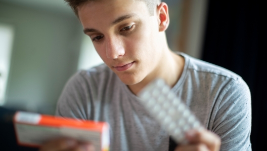 Teenage Boy With Mental Health Problems Taking Medication At Home