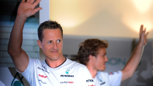 Mercedes driver Michael Schumacher (L) of Germany and his teammate and compatriot Nico Rosberg (R) wave during a meet the fans session ahead of the Formula One Malaysian Grand Prix in Kuala Lumpur on April 6, 2011. AFP PHOTO/ Saeed Khan