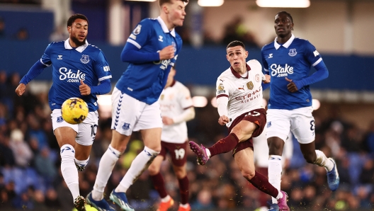 LIVERPOOL, ENGLAND - DECEMBER 27: Phil Foden of Manchester City takes a shot whilst under pressure from Arnaut Danjuma of Everton during the Premier League match between Everton FC and Manchester City at Goodison Park on December 27, 2023 in Liverpool, England. (Photo by Naomi Baker/Getty Images)