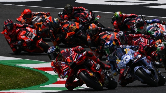 Pack of riders compete at the start of the race during the Italian MotoGP race at Mugello Circuit in Mugello, on June 11, 2023. (Photo by Filippo MONTEFORTE / AFP)