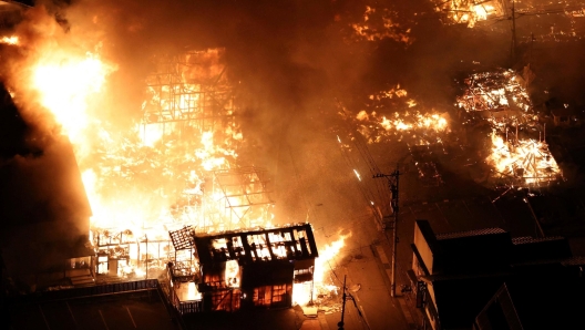 TOPSHOT - This aerial photo shows buildings burning in the city of Wajima, Ishikawa prefecture on January 1, 2024, after a major 7.5 magnitude earthquake struck the Noto region in Ishikawa prefecture in the afternoon. Tsunami waves over a metre high hit central Japan on January 1 after a series of powerful earthquakes that damaged homes, closed highways and prompted authorities to urge people to run to higher ground. (Photo by Yomiuri Shimbun / AFP) / Japan OUT / NO ARCHIVES - MANDATORY CREDIT: Yomiuri Shimbun