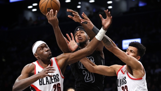 Brooklyn Nets center Day'Ron Sharpe (20) battles Portland Trail Blazers center Duop Reath (26) and forward Toumani Camara (33) for a rebound during the second half of an NBA basketball game, Sunday, Jan. 7, 2024, in New York.  (AP Photo/Noah K. Murray)