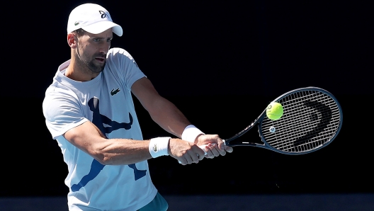 MELBOURNE, AUSTRALIA - JANUARY 09: Novak Djokovic of Serbia plays a backhand during a training session ahead of the 2024 Australian Open at Melbourne Park on January 09, 2024 in Melbourne, Australia. (Photo by Kelly Defina/Getty Images)