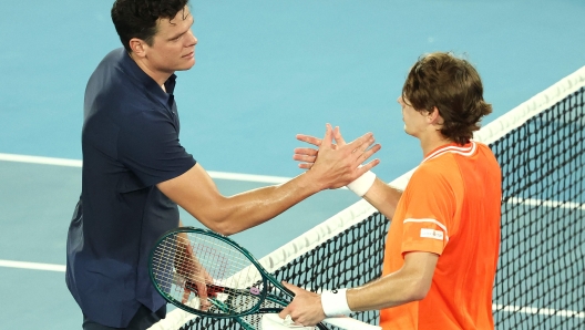 Australia's Alex De Minaur (R) shakes hands with Canada's Milos Raonic after their men's singles match on day two of the Australian Open tennis tournament in Melbourne on January 15, 2024. (Photo by David GRAY / AFP) / -- IMAGE RESTRICTED TO EDITORIAL USE - STRICTLY NO COMMERCIAL USE --