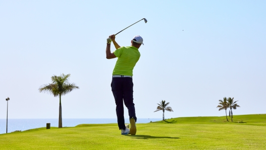 Golfer on a golf course, ready to tee off. Golfer with golf club hitting the ball for the perfect shot.