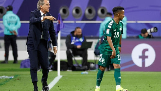 Saudi Arabia's Italian coach Roberto Mancini speaks to Saudi Arabia's midfielder #18 Abdulrahman Ghareeb during the Qatar 2023 AFC Asian Cup Group F football match between Saudi Arabia and Oman at the Khalifa International Stadium in Doha on January 16, 2024. (Photo by KARIM JAAFAR / AFP)