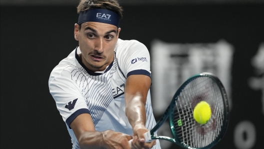 Lorenzo Sonego of Italy plays a backhand return to Daniel Evans of Britain during their first round match at the Australian Open tennis championships at Melbourne Park, Melbourne, Australia, Tuesday, Jan. 16, 2024. (AP Photo/Alessandra Tarantino)