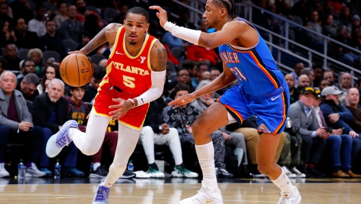 ATLANTA, GEORGIA - JANUARY 3: Dejounte Murray #5 of the Atlanta Hawks drives to the basket against Aaron Wiggins #21 of the Oklahoma City Thunder during the second half at State Farm Arena on January 3, 2024 in Atlanta, Georgia. NOTE TO USER: User expressly acknowledges and agrees that, by downloading and or using this photograph, User is consenting to the terms and conditions of the Getty Images License Agreement.   Todd Kirkland/Getty Images/AFP (Photo by Todd Kirkland / GETTY IMAGES NORTH AMERICA / Getty Images via AFP)