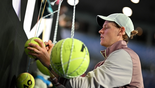 Italy's Jannik Sinner signs autographs to fans after his men's singles quarter-final match  against Russia's Andrey Rublev on day 10 of the Australian Open tennis tournament in Melbourne on January 24, 2024. (Photo by Anthony WALLACE / AFP) / -- IMAGE RESTRICTED TO EDITORIAL USE - STRICTLY NO COMMERCIAL USE --