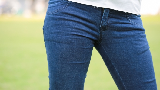 Closeup photo of Women wear blue jeans on green background