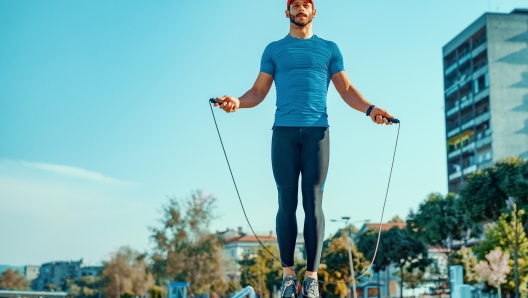 Attractive and muscular athlete.Young male athlete skipping rope.