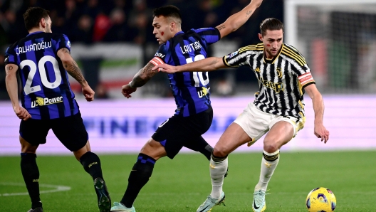 Juventus' French midfielder #25 Adrien Rabiot (R) and Inter Milan's Argentine forward #10 Lautaro Martinez (C) fight for the ball during the Italian Serie A football match between Juventus and Inter Milan at the Allianz Stadium in Turin, on November 26, 2023. (Photo by MARCO BERTORELLO / AFP)