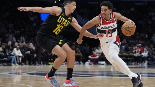 Washington Wizards guard Jordan Poole (13) drives past Utah Jazz forward Simone Fontecchio (16) during the second half of an NBA basketball game Thursday, Jan. 25, 2024, in Washington. (AP Photo/Mark Schiefelbein)