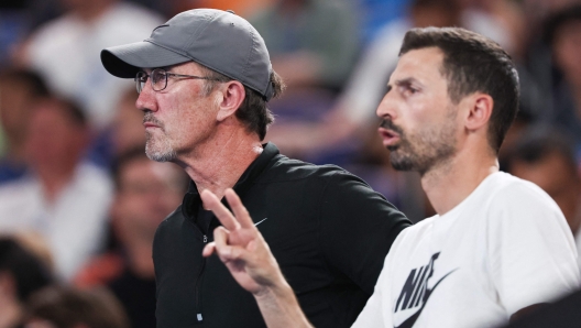 Darren Cahill (L), coach of Italy's Jannik Sinner, watches his player in action against Russia's Andrey Rublev during their men's singles quarter-final match on day 10 of the Australian Open tennis tournament in Melbourne on January 23, 2024. (Photo by David GRAY / AFP) / -- IMAGE RESTRICTED TO EDITORIAL USE - STRICTLY NO COMMERCIAL USE --