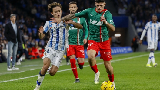 epa11053976 Real Sociedad's midfielder Takefusha Kubo (L) fights for the ball with Alaves' defender Javi Lopez during the Spanish LaLiga soccer match between Real Sociedad and Deportivo Alaves, in San Sebastian, Basque Country, Spain, 02 January 2024.  EPA/Juan Herrero