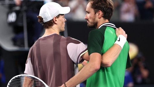 Italy's Jannik Sinner embraces Russia's Daniil Medvedev (R) after his victory in the men's singles final match on day 15 of the Australian Open tennis tournament in Melbourne on January 28, 2024. (Photo by David GRAY / AFP) / -- IMAGE RESTRICTED TO EDITORIAL USE - STRICTLY NO COMMERCIAL USE --