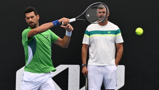 Serbia's Novak Djokovic attends a training session next to his coach Goran Ivanisevic (R) on day 12 of the Australian Open tennis tournament in Melbourne on January 25, 2024. (Photo by Paul Crock / AFP) / -- IMAGE RESTRICTED TO EDITORIAL USE - STRICTLY NO COMMERCIAL USE --