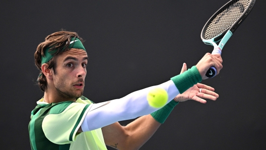 Italy's Lorenzo Musetti hits a return against France's Luca Van Assche during their men's singles match on day four of the Australian Open tennis tournament in Melbourne on January 17, 2024. (Photo by Anthony WALLACE / AFP) / -- IMAGE RESTRICTED TO EDITORIAL USE - STRICTLY NO COMMERCIAL USE --