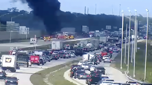 In this image provided by the Florida Department of Transportation, Florida Highway Patrol troopers are on the scene of a small airplane landing on southbound Interstate 75 in Naples, Fla., Friday, Feb. 9, 2024. The plane collided with a vehicle as it made the emergency landing. (Florida DOT/The News-Press via AP)