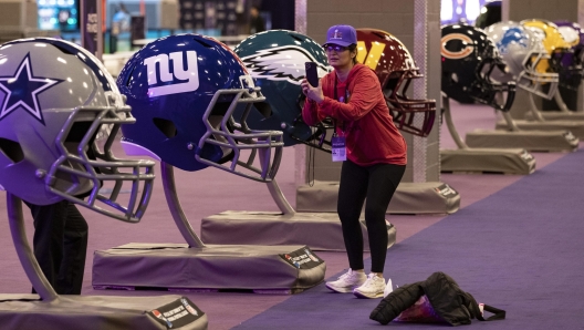 epa11138134 A woman takes a picture of supersized football helmets at the Super Bowl Experience at Mandalay Bay South Convention Center in Las Vegas, Nevada, USA, 08 February 2024. The AFC champion Kansas City Chiefs will face the NFC champion San Francisco 49ers in Super Bowl LVIII at State Allegiant Stadium in Las Vegas, Nevada, on 11 February 2024.  EPA/ETIENNE LAURENT