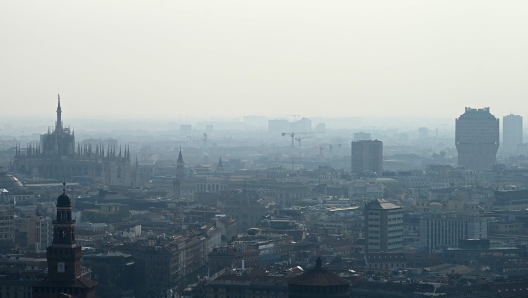 TOPSHOT - A blanket of smog covers Milan's skyline with the Duomo (L) and the Velasca tower (R) on February 21, 2024 in Milan. Gas-guzzling cars were banned from roads Tuesday in Milan and eight other cities across Lombardy after the northern Italian industrial region registered high levels of particle pollution dangerous for health. (Photo by GABRIEL BOUYS / AFP)