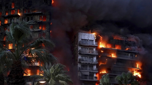 Flames devour a building in the Campanar neighborhood, February 22, 2024, in Valencia, Valencian Community (Spain). A large fire has devastated a 14-storey building in the Campanar district of Valencia. The fire, which originated on the fourth floor of the building, has generated a large column of flames and a dense smoke that has affected several floors of the building. The 112 has mobilized ten firefighters, two SAMU and a SVB to the scene of the fire. FEBRUARY 22;2024 Eduardo Manzana / Europa Press 02/22/2024 (Europa Press via AP)