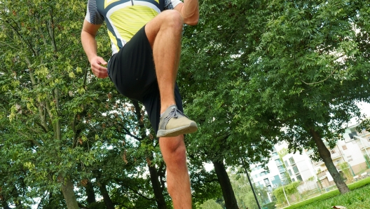 Young handsome guy in sportswear suit running outdoors in park