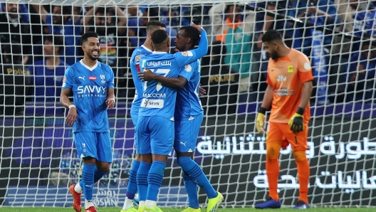 RIYADH, SAUDI ARABIA - MARCH 01: Saud Abdulhamid of Al Hilal celebrates scoring his team's third goal with teammates as Abdullah Al-Mayouf of Al Ittihad reacts after failing to make a save during the Saudi Pro League match between Al-Hilal and Al-Ittihad at Kingdom Arena on March 01, 2024 in Riyadh, Saudi Arabia. (Photo by Yasser Bakhsh/Getty Images)