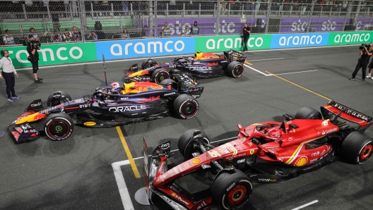 Winner Red Bull Racing's Dutch driver Max Verstappen (L), second placed Red Bull Racing's Mexican driver Sergio Perez (back) and third placed Ferrari's Monegasque driver Charles Leclerc line up their cars after the Saudi Arabian Formula One Grand Prix at the Jeddah Corniche Circuit in Jeddah on March 9, 2024. (Photo by Giuseppe CACACE / AFP)