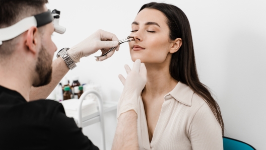 Rhinoscopy of woman nose. Consultation with ENT doctor. Otolaryngologist examines girl nose before procedure of endoscopy of nose