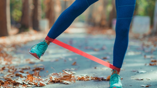 Woman Exercising Legs with Resistance Band Outdoors