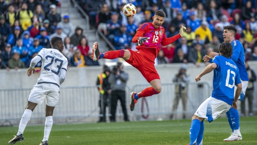 Italy's goalkeeper Guglielmo Vicario (12) jumps to control the ball against Ecuador's midfielder Moises Caicedo (23) during an international friendly soccer match, Sunday, March 24, 2024, in Harrison, N.J. (AP Photo/Eduardo Munoz Alvarez)