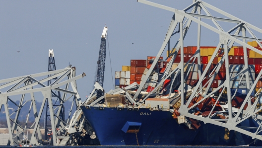 Cranes stand by as the wreckage of the Francis Scott Key Bridge rests on the container ship Dali, Saturday, March 30, 2024, in Baltimore. (AP Photo/Julia Nikhinson)