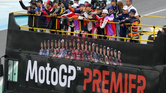 FILE - Moto GP competitors wave from a bus during the Riders Fan Parade at Termas de Rio Hondo circuit in Argentina, Sunday, April 2, 2023. Liberty Media Corp., the American company that owns Formula 1, is adding to its global racing portfolio with the purchase of the MotoGP motorcycle racing series by the end of the year, MotoGP officials announced Monday, April 1, 2024. (AP Photo/Natacha Pisarenko, File)