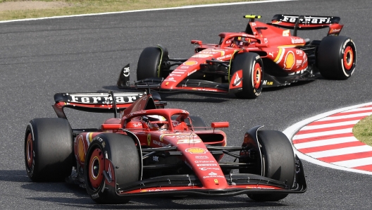 Ferrari's Monegasque driver Charles Leclerc (bottom) and Ferrari's Spanish driver Carlos Sainz Jr (behind) take a turn during the Formula One Japanese Grand Prix race at the Suzuka circuit in Suzuka, Mie prefecture on April 7, 2024. (Photo by Toshifumi KITAMURA / AFP)