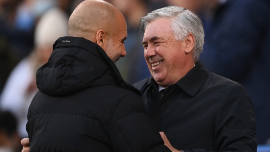 MANCHESTER, ENGLAND - APRIL 26: Pep Guardiola, Manager of Manchester City and Carlo Ancelotti, Head Coach of Real Madrid interact prior to the UEFA Champions League Semi Final Leg One match between Manchester City and Real Madrid at Etihad Stadium on April 26, 2022 in Manchester, England. (Photo by Laurence Griffiths/Getty Images)