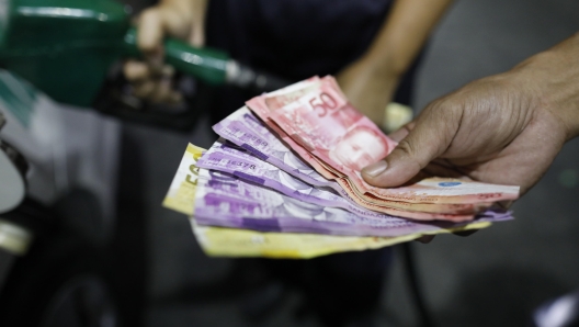 epa11129451 A motorists holds bills next to a gasoline attendant filling a vehicle as fuel prices are expected to rise, at a station in Manila, Philippines, 05 February 2024. Motorists in the Philippines will see another increase of petroleum products prices effective from 06 February, which the Philippines' Department of Energy Oil Industry Management Bureau said was due to disruption of supplies and proposed extension of the Organization of the Petroleum Exporting Countries (OPEC) cuts by 2.2 million barrels per day until the first quarter of 2024.  EPA/FRANCIS R. MALASIG