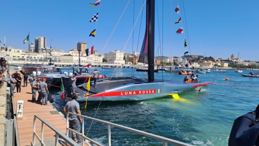 Varata la nuova Ac75 di Luna Rossa a Cagliari, 13 aprile 2024. Con la benedizione del vescovo Giuseppe Baturi  scattato alle 13.23 il via alla nuova avventura della barca che cercher di portare in Italia la Coppa America. La madrina dell'inaugurazione  stata come al solito Miuccia Prada accompagnata dal patron Patrizio Bertelli. Poi la fatidica frase 'Io ti battezzo Luna Rossa'. Con la bottiglia di spumante che si  schiantata sulla scocca argentata della nuova barca dai colori argento, grigio e rosso con due ali gialle che la faranno "volare" sull'acqua. Uno scafo molto affusolato per affrontare meglio le onde. ANSA/ ROBERTA CELOT