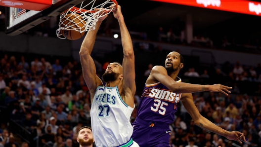 MINNEAPOLIS, MINNESOTA - APRIL 14: Rudy Gobert #27 of the Minnesota Timberwolves dunks the ball against Kevin Durant #35 of the Phoenix Suns in the fourth quarter at Target Center on April 14, 2024 in Minneapolis, Minnesota. The Suns defeated the Timberwolves 125-106. NOTE TO USER: User expressly acknowledges and agrees that, by downloading and or using this photograph, User is consenting to the terms and conditions of the Getty Images License Agreement.   David Berding/Getty Images/AFP (Photo by David Berding / GETTY IMAGES NORTH AMERICA / Getty Images via AFP)