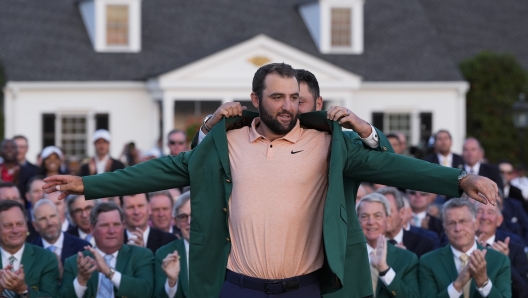 Jon Rahm, of Spain, puts the green jacket on winner Scottie Scheffler after the Masters golf tournament at Augusta National Golf Club Sunday, April 14, 2024, in Augusta, Ga. (AP Photo/David J. Phillip)