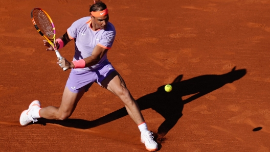 TOPSHOT - Spain's Rafael Nadal returns the ball to Italy's Flavio Cobolli during the ATP Barcelona Open "Conde de Godo" tennis tournament singles match at the Real Club de Tenis in Barcelona, on April 16, 2024. (Photo by Pau Barrena / AFP)