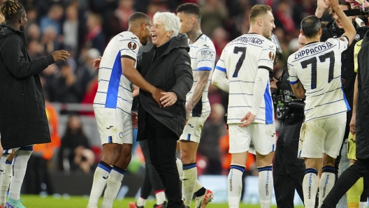 Atalanta's head coach Gian Piero Gasperini, third from left, celebrates with his players at the end of the Europa League quarter final first leg soccer match between Liverpool and Atalanta, at the Anfield stadium in Liverpool, England, Thursday, April 11, 2024. Atalanta won 3-0. (AP Photo/Jon Super)