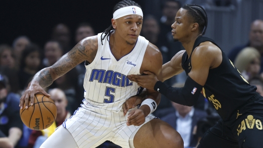 Orlando Magic forward Paolo Banchero (5) plays against Cleveland Cavaliers forward Isaac Okoro (35) during the first half of Game 5 of an NBA basketball first-round playoff series, Tuesday, April 30, 2024, in Cleveland. (AP Photo/Ron Schwane)