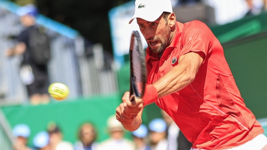 Serbia's Novak Djokovic plays a backhand return to Italy's Lorenzo Musetti during their Monte Carlo ATP Masters Series Tournament round of 16 tennis match on the Rainier III court at the Monte Carlo Country Club on April 11, 2024. (Photo by Valery HACHE / AFP)