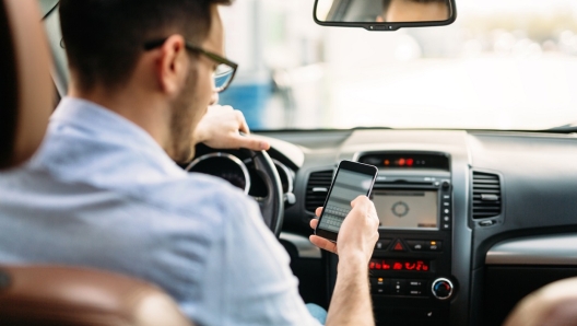 transportation concept - man using phone while driving the car