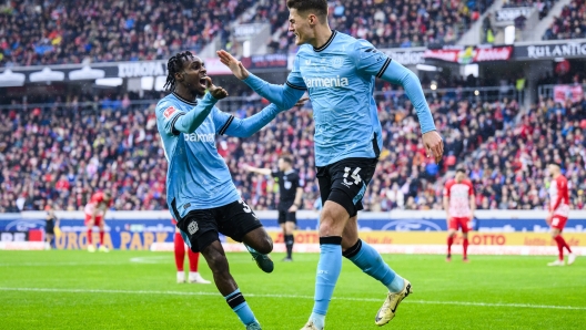 Leverkusen's Patrik Schick, right, celebrates with Leverkusen's Jeremie Frimpong after scoring their side's third goal of the game during the Bundesliga soccer match between Bayer Leverkusen and SC Freiburg at the Europa-Park Stadium in Freiburg im Breisgau, Germany, Sunday March 17, 2024. (Tom Weller/dpa via AP)