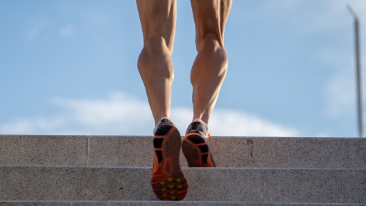 Man runner running on stairs in urban city sport training young male jogger athlete training and doing workout outdoors in city. Fitness and exercising outdoors urban environment concept.