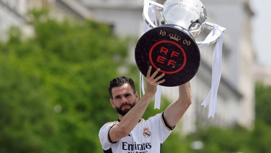 Real Madrid's Spanish defender #06 Nacho Fernandez holds their 36th Liga as Real Madrid' players parade onboard a bus during celebration at the Cibeles square in Madrid on May 12, 2024. Real Madrid's fans line the streets of Madrid as 'Los blancos' celebrate their 36th Liga trophy before facing Borussia Dortmund at Wembley in the Champions League final on June 1. (Photo by OSCAR DEL POZO / AFP)